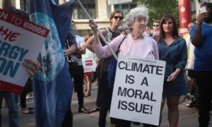 Environmental activists protest Donald Trump’s decision to exit the Paris climate accords, which set a goal of avoiding warming beyond 2C. Photograph: Scott Olson/Getty Images
